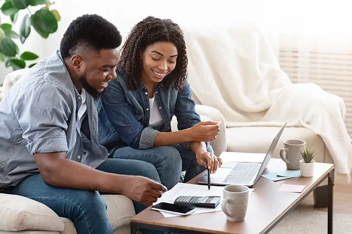 Smiling Black Couple Discussing Total Amount Of Their Spends At Home
