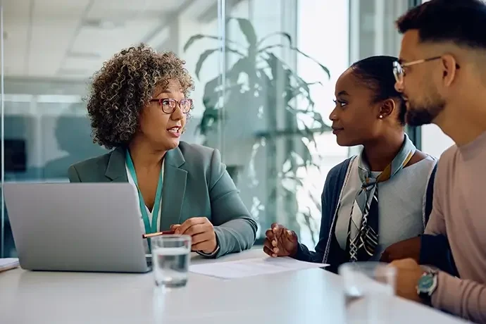 Financial advisor talking to young couple during meeting in office.