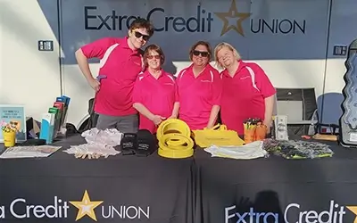 Extra Credit Union employees at a booth outside