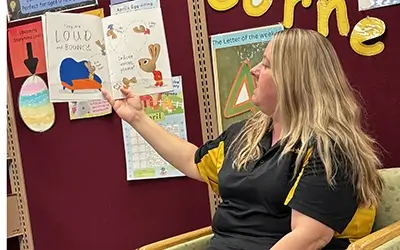 Extra Credit Union reading to students at a school