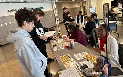 Extra Credit Union speaking with students at a school